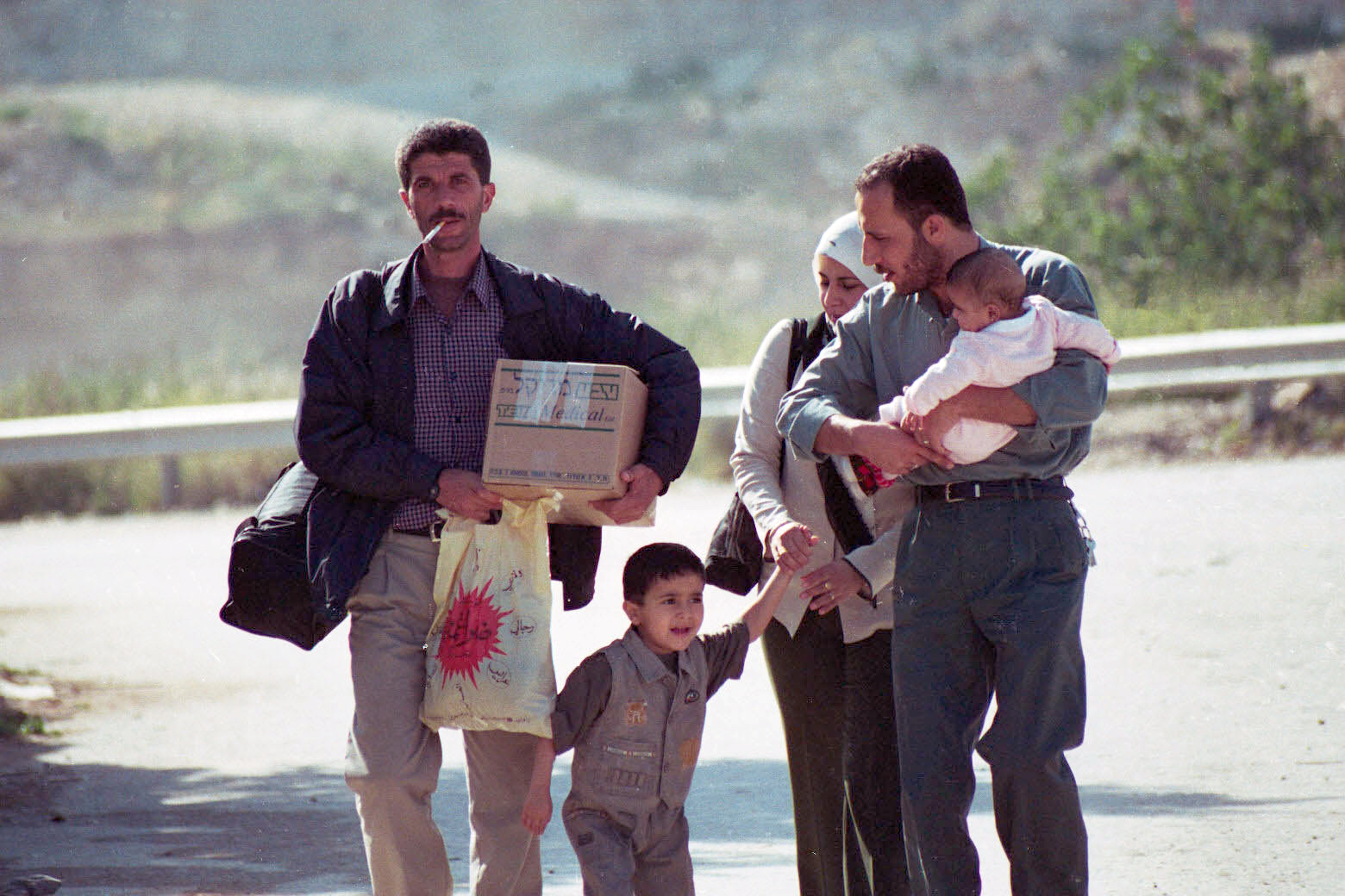 Persone che passano a piedi per Surda dopo la distruzione e la chiusura della strada (Yousef al-Qutub, 2002) - The Palestinian Museum Digital Archive